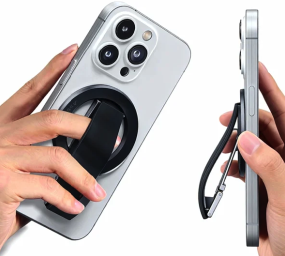 Magnetic phone grip and kickstand accessory on a silver iPhone, demonstrating finger hold and stand function.