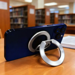 Dark blue smartphone with silver magnetic ring holder stand on library table.